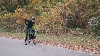 英俊的<strong>自行车</strong>手开始在秋天的城市公园骑<strong>公路自行车</strong>。 三项运动员骑在<strong>公路自行车</strong>上。 一个在布劳的男人